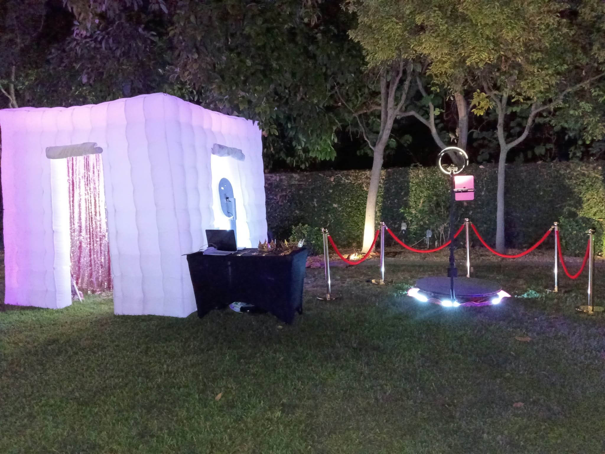 White inflatable photo booth and illuminated 360 platform at an outdoor event